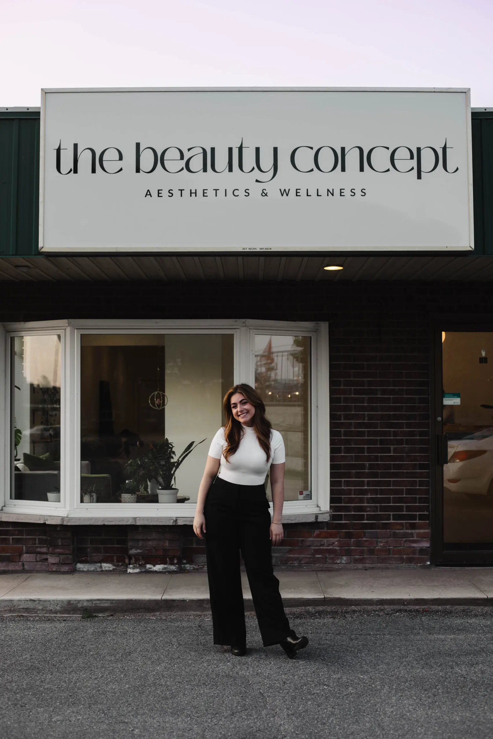 Katie standing outside The Beauty Concept storefront in Kingston